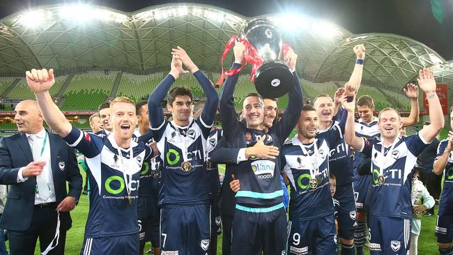 Carl Valeri holds the FFA Cup trophy aloft.