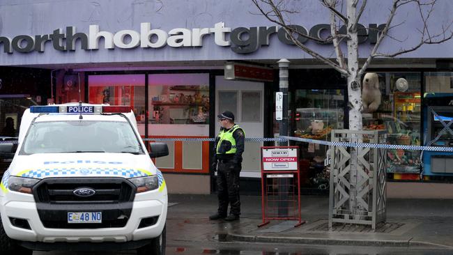 A police officer outside Mrs Delios’s North Hobart shop after Mrs Delios was stabbed. Picture: LUKE BOWDEN