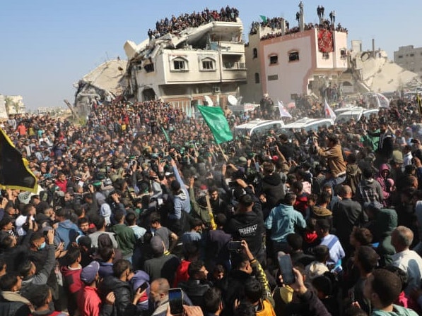 A crowd gathered Thursday outside the Gaza home of a slain Hamas leader to watch the release of hostages. Picture: Naaman Omar/Apaimages/Zuma Press