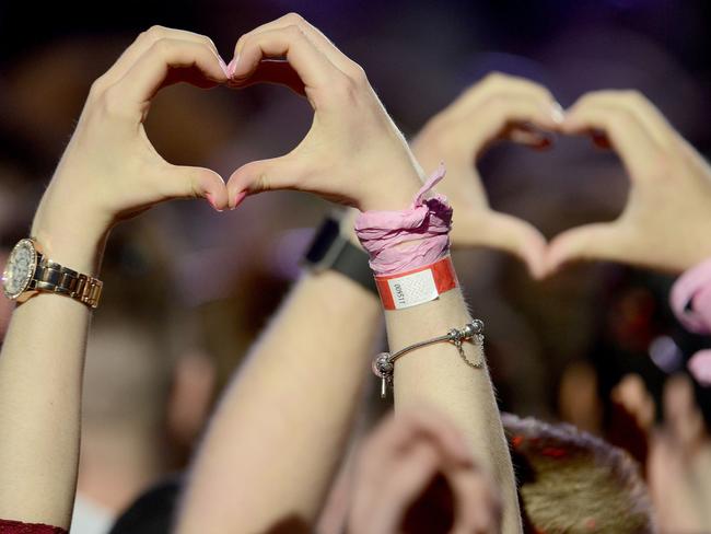 In this Sunday, June 4, 2017, handout photo provided by Dave Hogan for One Love Manchester, fans make heart shapes from their hands at the One Love Manchester tribute concert in Manchester, north western England, Sunday, June 4, 2017. Picture: Dave Hogan via AP