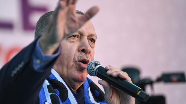 Turkish President Recep Tayyip Erdogan sings his election song before delivering a speech at an election rally in Istanbul's Kasimpasa district, on March 5, 2019. - Turkish leader is picking up the microphone to croon, complete with hand gestures, as he campaigns for March 31 ballot to rally supporters for his ruling AKP party.Music has always been a powerful tool in Turkish politics but with Erdogan and his Justice and Development Party (AKP), it has become an indispensible weapon. (Photo by Ozan KOSE / AFP)