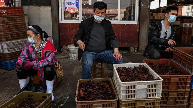 Vendors wearing face masks as they offer prawns for sale at the Wuhan Baishazhou Market in Wuhan in China's central Hubei province. Photo: Hector Retamal/AFP