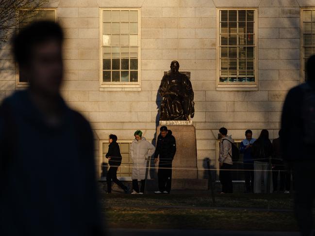 CAMBRIDGE, MASSACHUSETTS - APRIL 17: People gather to take photos with the John Harvard Statue at Harvard University on April 17, 2025 in Cambridge, Massachusetts. The Trump administration announced that it would block Harvard University from receiving $2.2 billion in federal grants and $60 million in contracts after the school refused demands to adopt new policies relating to student and faculty conduct, admissions, anti-semitism on campus and DEI.   Sophie Park/Getty Images/AFP (Photo by Sophie Park / GETTY IMAGES NORTH AMERICA / Getty Images via AFP)