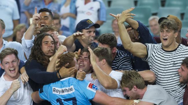 Harry Johnson-Holmes celebrates with fans after the Tahs won in round two.