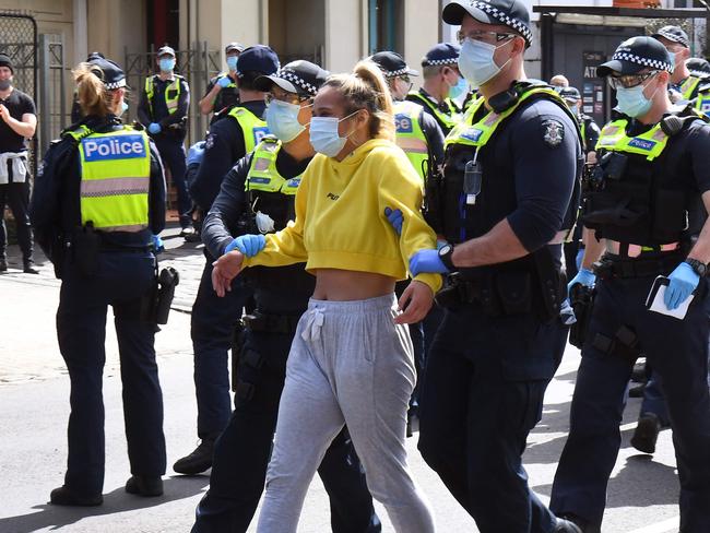 Police detain an anti-lockdown protester at Melbourne's Queen Victoria Market during a rally on September 13, 2020, amid the ongoing COVID-19 coronavirus pandemic. - Melbourne continues to enforce strict lockdown measures to battle a second wave of the coronavirus. (Photo by William WEST / AFP)
