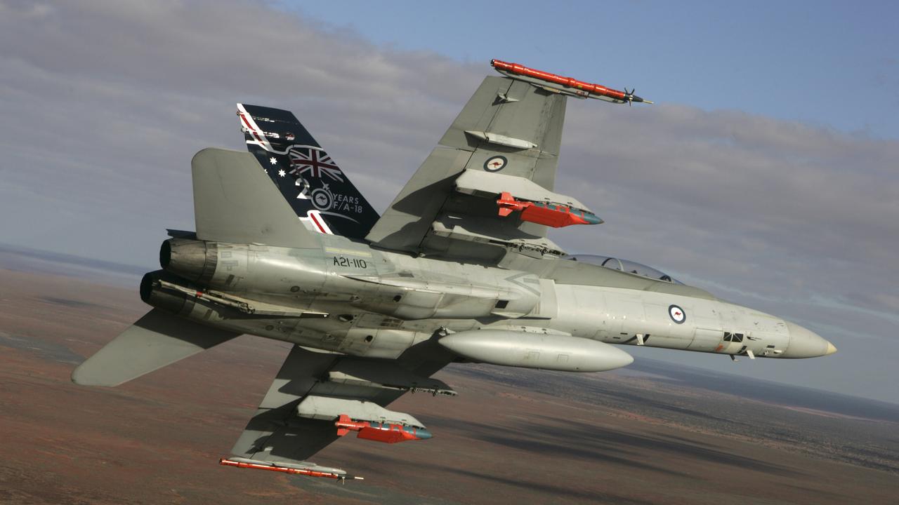 A Royal Australian Air Force F/A-18 Hornet in flight with two JDAM-ER 500lb bombs and two Time Space Position Information pods at Woomera, South Australia.