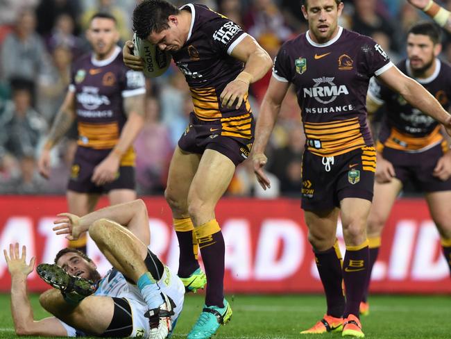 Broncos player James Roberts (second left) kicks Titans player Ryan Simpkins during the NRL Elimination Final between the Brisbane Broncos and Gold Coast Titans at Suncorp Stadium in Brisbane, Friday, Sept. 9, 2016. (AAP Image/Dave Hunt) NO ARCHIVING, EDITORIAL USE ONLY