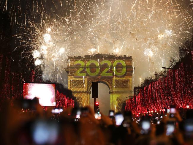 Revellers photograph fireworks over the Arc de Triomphe. Picture: AP