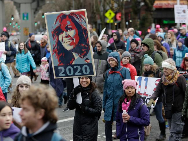 Michelle Obama remains a strong touchstone of values for many female voters. Here a woman carries a sign urging the First Lady to consider a presidential run, two years from now. Picture: AFP/Jason Redmond