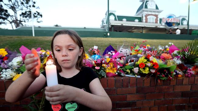 Ella Cowen (10) leaving a tribute to the Dreamworld tragedy victims. Picture: Richard Gosling