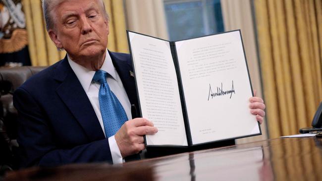 WASHINGTON, DC - JANUARY 31: U.S. President Donald Trump hold up an executive order, "Unleashing prosperity through deregulation," that he signed in the Oval Office on January 31, 2025 in Washington, DC. Trump spoke to reporters about tariffs against China, Canada and Mexico and how the newly confirmed Interior Secretary Doug Burghum will coordinate with the Energy Department and the Environmental Protection Agency.   Chip Somodevilla/Getty Images/AFP (Photo by CHIP SOMODEVILLA / GETTY IMAGES NORTH AMERICA / Getty Images via AFP)