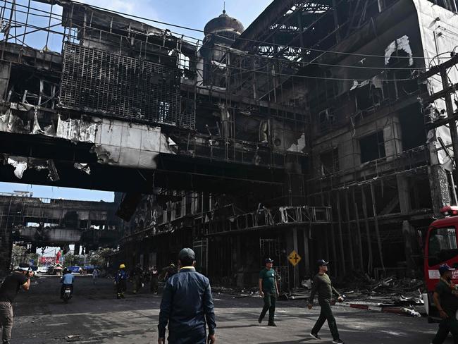 People next to a destroyed part of the Grand Diamond City hotel-casino after a fire in Poipet on December 29, 2022. Picture: Lillian Suwanrumpha / AFP.