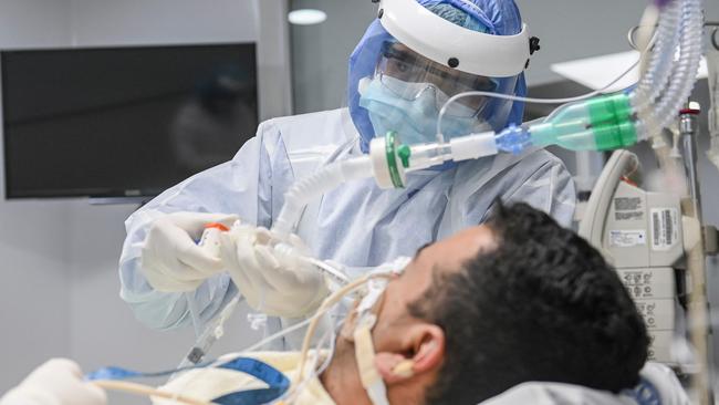 Respiratory therapist Juan Pablo Sanchez treats a patient infected with COVID-19 at the Intensive Care Unit (ICU) of the CES Clinic in Medellin, Colombia in July. Photo: AFP.