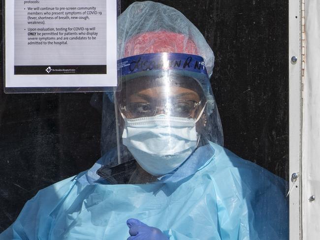 FILE  - In this March 26, 2020 file photo a member of the Brooklyn Hospital Center COVID-19 testing team calls in the next patient in line in the Brooklyn borough of New York. Having access to quick coronavirus test results will play an important role in resuming sporting events, keeping factories and businesses open, and returning to school in the fall. But an Associated Press survey of selected states found itÃ¢â¬â¢s still taking days in some cases for results to come back despite an increase in the availability of testing across the U.S. Public health experts say testing delays present a major hurdle to reducing infections. (AP Photo/Mary Altaffer, File)