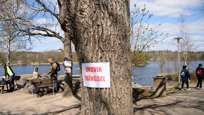 A sign on a tree reads "Avoid congestion" at the popular recreational area Hellasgarden in the outskirts of Stockholm. Picture: Henrik Montgomery / via AFP