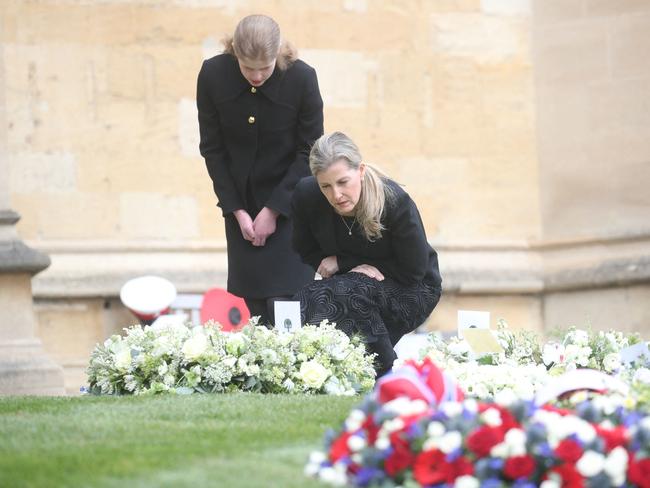 Sophie, Countess of Wessex, and her daughter, Lady Louise Windsor read tributes left for Prince Philip outside of Windsor Castle. Picture: AFP