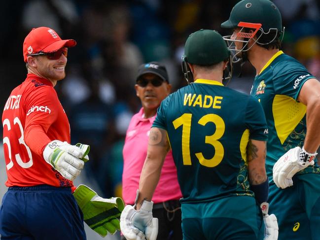 England's captain Jos Buttler (L) talks to Australia's Matthew Wade during the ICC men's Twenty20 World Cup 2024 group B cricket match between Australia and England at Kensington Oval in Bridgetown, Barbados, on June 8, 2024. (Photo by Randy Brooks / AFP)