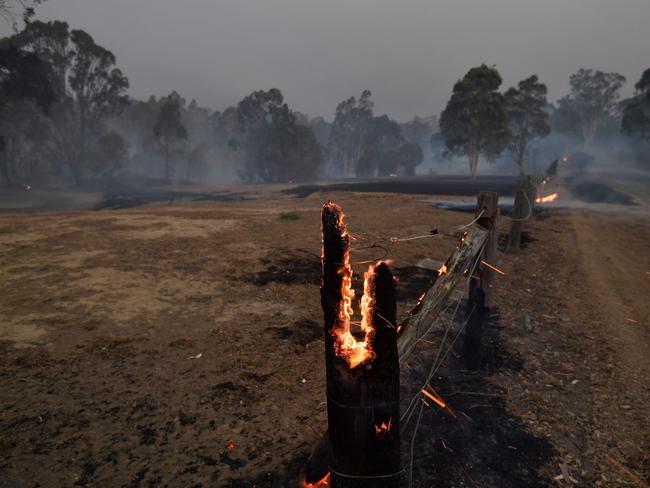 A burning fencepost is pictured on a residential property as bushfires hit the area around the town of Nowra in the Australian state of New South Wales on December 31, 2019. - Thousands of holidaymakers and locals were forced to flee to beaches in fire-ravaged southeast Australia on December 31, as blazes ripped through popular tourist areas leaving no escape by land. Picture: Saeed Khan/AFP