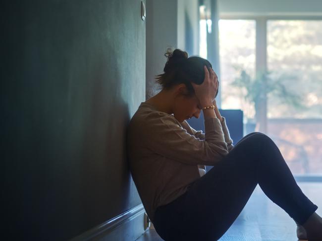 istock generic:  woman, abuse, DV, domestic violence, harassment, sexual harassment.   Sad Young Woman Sitting on the Floor In the Hallway of Her Appartment, Covering Face with Hands. Atmosphere of Depression, Trouble in Relationship, Death in the Family. Dramatic Bad News Moment . Picture: istock