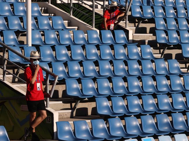 Officials wear face masks as they stand next to empty spectator stands during the men's singles match on day three of the Australian Open on February 10, 2021. Picture: AFP