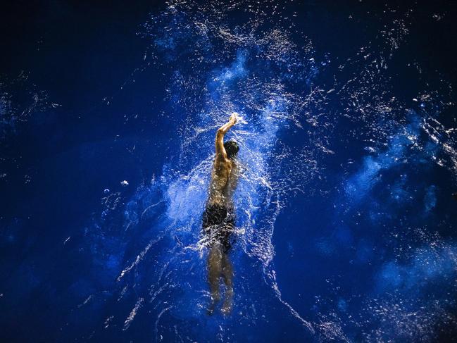 Soar in the blue ...There was a diving practice, after that, the swimming coach was swimming in the pool, and I was standing in the 5m diving platform, waiting for the right moment, although the light was quiet dim, I still managed to get this shot. Picture: Zuorong Li, China, Entry, Open, Motion, 2017 Sony World Photography Awards
