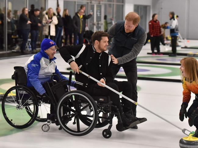 Canadian singer Michael Buble takes a shot during a wheelchair curling demonstration while Prince Harry. Picture: AFP