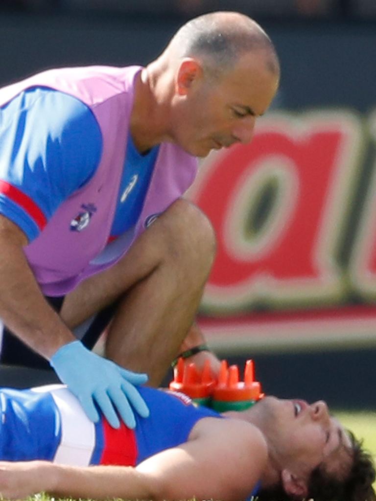 Former Bulldog Liam Picken is treated after being knocked out.