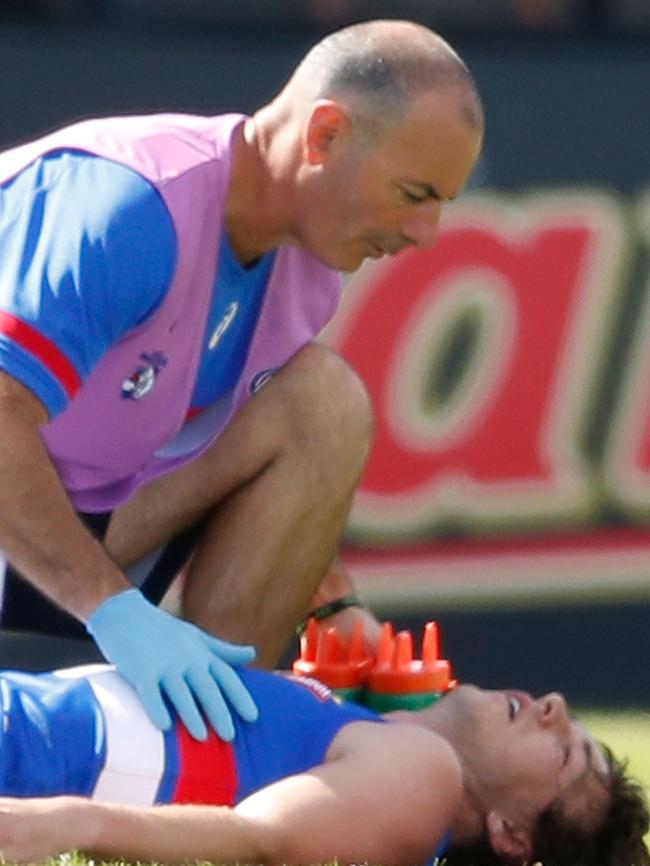 Former Bulldog Liam Picken is treated after being knocked out.