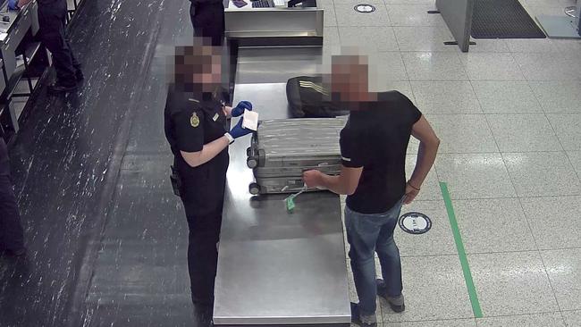 A Bulgarian national has his devices and baggage searched by the Australian Border Force at Perth International Airport in August. His visa was cancelled and he was immediately deported after Border Force discovered evidence he was prepared for a credit-card skimming operation. Picture: Australian Border Force