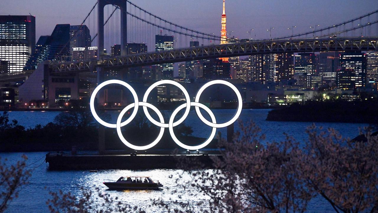 A boat sails past the Tokyo 2020 Olympic Rings on March 25, 2020 in Tokyo, Japan.*