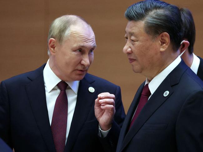 Russian President Vladimir Putin speaks to China's President Xi Jinping during the Shanghai Cooperation Organisation (SCO) leaders' summit in Samarkand on September 16, 2022. (Photo by Sergei BOBYLYOV / SPUTNIK / AFP)