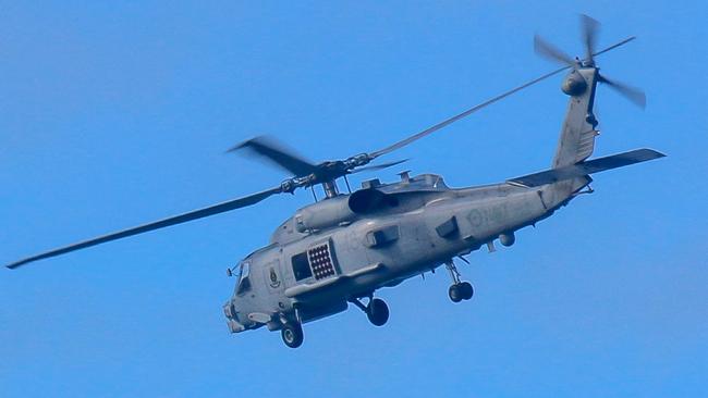 This handout photo taken on July 29, 2023 and received on July 30 from the Australian Defence shows a Royal Australian Navy helicopter conduct search and rescue operations in the vicinity of Lindeman Island, Queensland. Australia's military will ground its fleet of MRH-90 Taipan helicopters after a crash during multinational military exercises that left four crew members missing, the army chief said on July 30. (Photo by AUSTRALIAN DEFENCE / AFP) / ----EDITORS NOTE ----RESTRICTED TO EDITORIAL USE MANDATORY CREDIT " AFP PHOTO / AUSTRALIAN DEFENCE" NO MARKETING NO ADVERTISING CAMPAIGNS - DISTRIBUTED AS A SERVICE TO CLIENTS