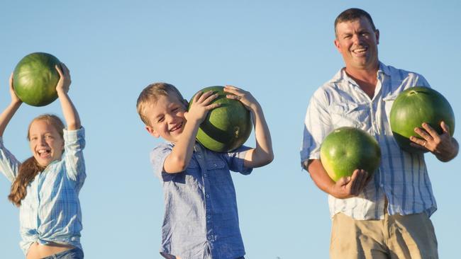 Glen with kids Lilly, 10 and Charlie, 6 on their 3rd generation farm in Nangiloc. Charlie, 6 struggles to lift one of the fresh melons from the filed. Picture: Jason Edwards