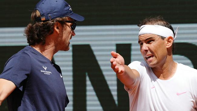 TOPSHOT - Spain's Rafael Nadal (R) speaks with his coach Carlos Moya during a practice session ahead of The French Open tennis tournament on Court Philippe-Chatrier at The Roland Garros Complex in Paris on May 21, 2024. (Photo by Dimitar DILKOFF / AFP)