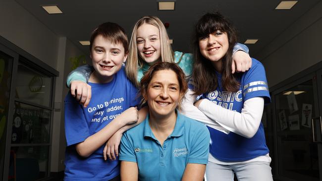 Homely Retreats founder Jay Chipman alongside students Liam Harvey, 13, Halle Watt, 14 and Shinae Borg, 13 who dressed in blue to raise awareness for Homely Retreats who provide respite for young Tasmanian families affected by cancer. Picture: Zak Simmonds