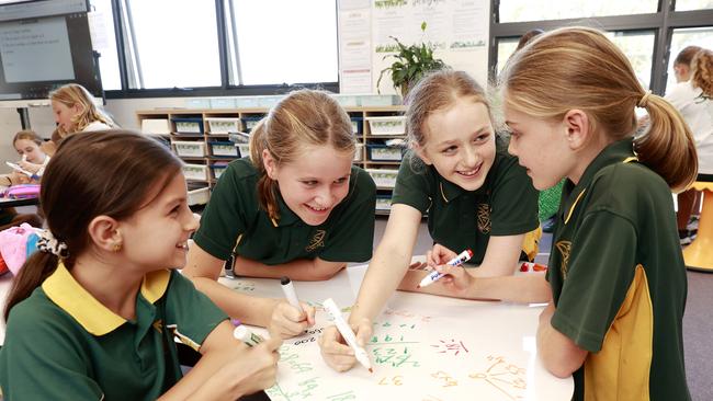 Curl Curl North Public School students Keira Stephens 10, Rosie Lawry 10, Matisse Hayes Black 11 and Carmen Schreiber 10, sitting on the floor and using the whiteboard desks to do their work on. Picture: Tim Hunter