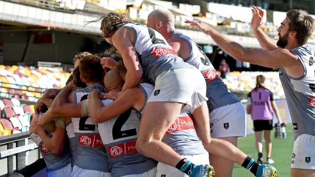 Robbie Gray is mobbed by teammates after kicking the winning goal against Carlton. Picture: Bradley Kanaris (Getty).