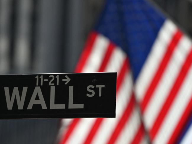 (FILES) In this file photo taken on February 17, 2021 a Wall Street sign at the New York Stock Exchange (NYSE) is seen in New York, New York. - Major US stock indices dropped at the open of the session on November 26, 2021, a holiday-shortened session following the announcement of a new Covid-19 variant that has prompted travel restrictions. (Photo by Angela Weiss / AFP)