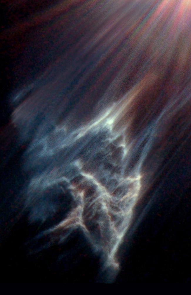 The Hubble Space Telescope has caught the eerie, wispy tendrils of a dark interstellar cloud being destroyed by the passage of one of the brightest stars in the Pleiades star cluster. Like a flashlight beam shining off the wall of a cave, the star is reflecting light off the surface of pitch black clouds of cold gas laced with dust. These are called reflection nebulae.