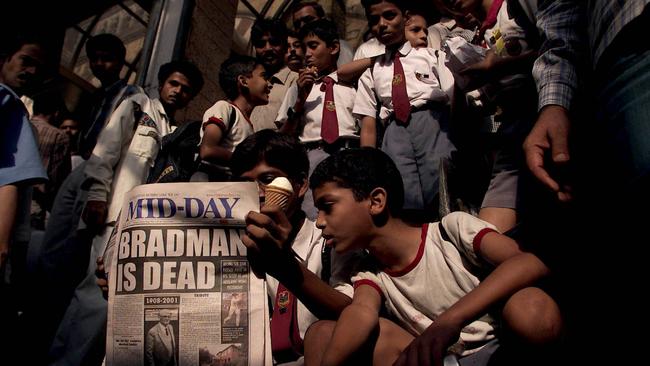 School children read a Mumbai newspaper announcing the death or Don Bradmanin 2001. Picture: Phil Hillyard