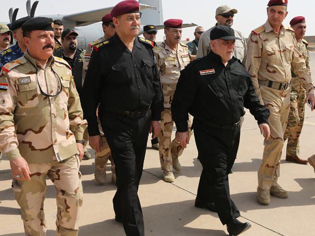 Iraqi Prime Minister Haider al-Abadi (third from right) walking alongside police and army officers upon his arrival in Mosul on Sunday. Picture: AFP