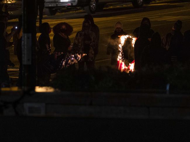 Members of an Antifa group burn an American flag prior to clashes with a group of Proud Boys. Picture: AFP