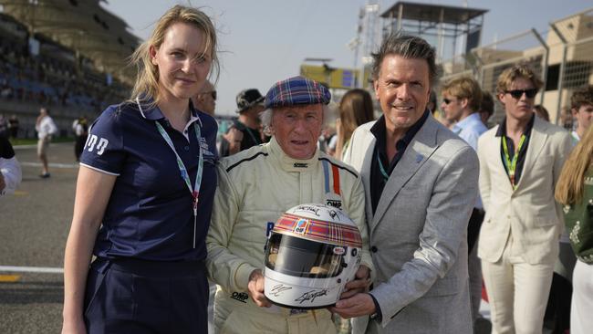 Former Formula One Champion Jackie Stewart holds a helmet signed by formula one drivers before the Formula One Bahrain Grand Prix. (AP Photo/Altaf Qadri)