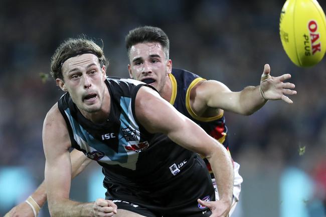 Power’s Jarrod Lienert fires off the handball under pressure from Adelaide’s Lachlan Murphy in Showdown 46 at Adelaide Oval. . Picture Sarah Reed 