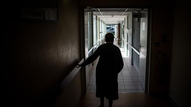 (FILES) In this file photo taken on March 30, 2021 an elderly woman walks along a corridor at the "Residence des Glenans" EHPAD (Establishment for the Housing of Elderly Dependant People) in Haute-Goulaine, outside Nantes, western France, amid the Covid-19 pandemic. - Not following the government's position, the National Assembly voted on July 22, 2021 against the use of the health pass for non-emergency patients or visitors in health facilities and care homes. (Photo by LOIC VENANCE / AFP)