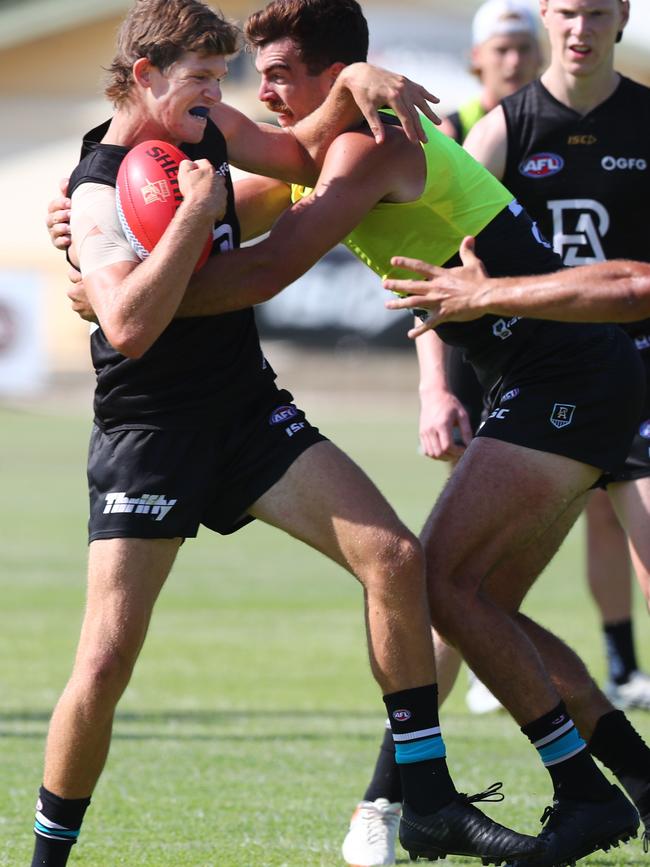 … and is tackled by Port Adelaide teammate Scott Lycett in a training drill at Alberton.