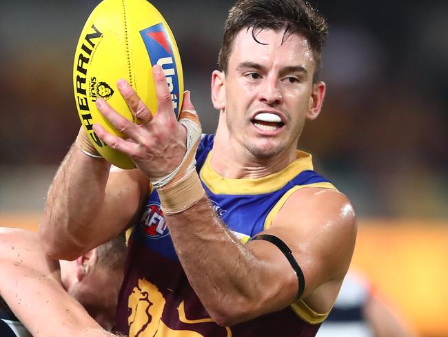 BRISBANE, AUSTRALIA - JUNE 24: Jarryd Lyons of the Lions handballs while tackled by Joel Selwood of the Cats during the round 14 AFL match between the Brisbane Lions and the Geelong Cats at The Gabba on June 24, 2021 in Brisbane, Australia. (Photo by Chris Hyde/AFL Photos/via Getty Images)