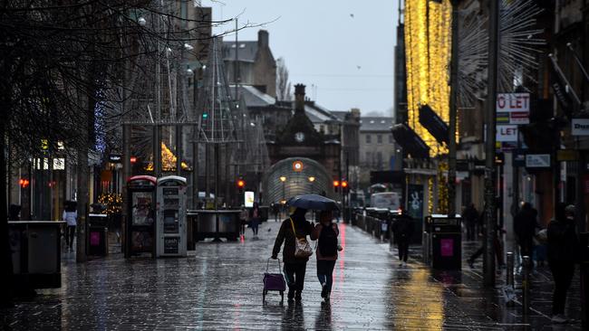 Pedestrians walk along a near-deserted Buchanan Street in central Glasgow. Picture: AFP.