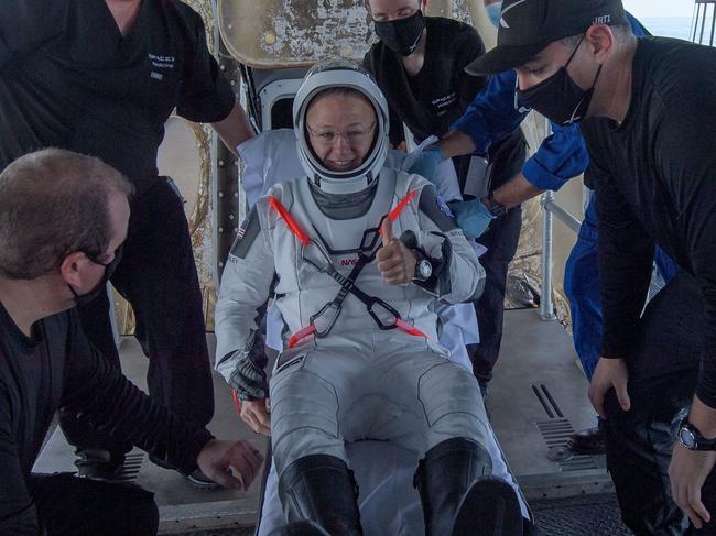 This handout photo released courtesy of NASA shows NASA astronaut Douglas Hurley is helped out of the SpaceX Crew Dragon Endeavour spacecraft onboard the SpaceX GO Navigator recovery ship after he and NASA astronaut Robert Behnken landed in the Gulf of Mexico off the coast of Pensacola, Florida, on August 2, 2020. - SpaceX's crewed capsule isn't called Dragon for nothing. The two NASA astronauts brought back to Earth on August 2 said they felt they were inside the belly of a beast as it careened into the atmosphere at 17,500 mph. "It came alive," said mission commander Bob Behnkhen at a virtual press conference held August 4 in Houston, Texas. hnken and Hurley are returning after spending 64 days in space. (Photo by Bill INGALLS / NASA / AFP) / RESTRICTED TO EDITORIAL USE - MANDATORY CREDIT "AFP PHOTO /NASA/BILL INGALLS/HANDOUT " - NO MARKETING - NO ADVERTISING CAMPAIGNS - DISTRIBUTED AS A SERVICE TO CLIENTS