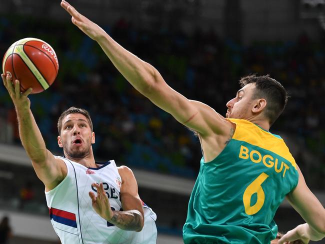 Serbian guard Stefan Jovic (L) goes to the basket despite Australian centre Andrew Bogut’s attentions.